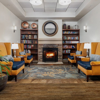 A room with a fireplace and chairs.